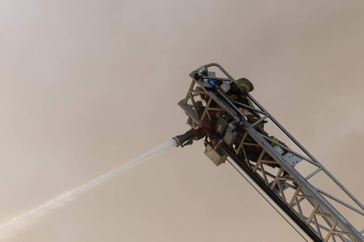 A firefighter is almost enveloped in smoke as he tries to put out the massive blaze that erupted in East St. Louis on Thursday.
