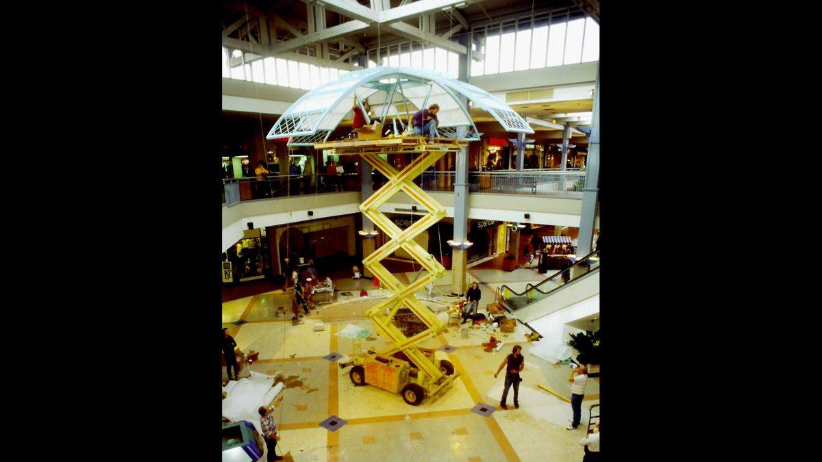 Installation of a 24-foot-wide artwork above the center court at St. Clair Square. The mall’s 1992-93 renovation included the removal of the fountains and plants.