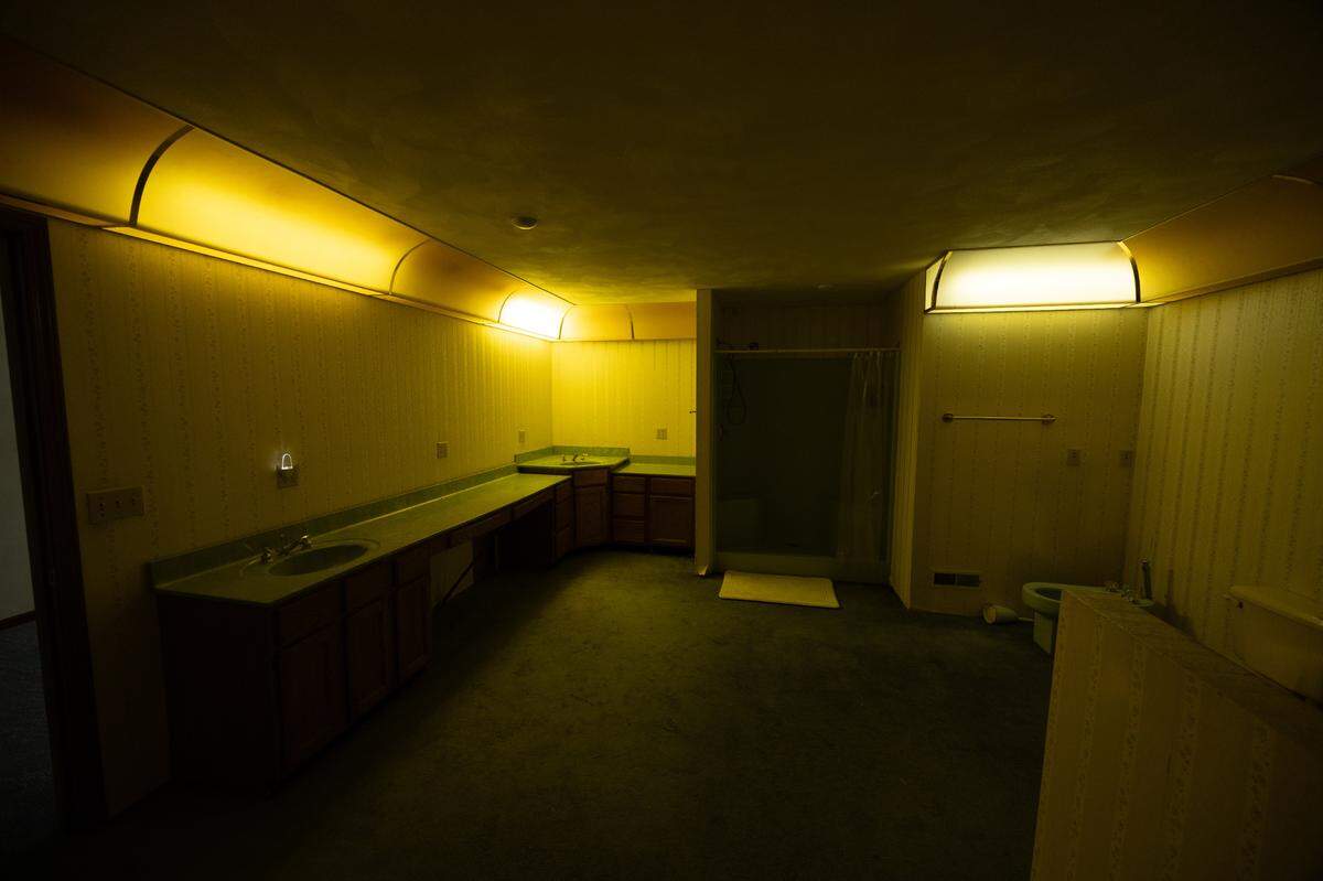 This bathroom and jacuzzi room has unique lighting along its walls, giving it a warm glow.
