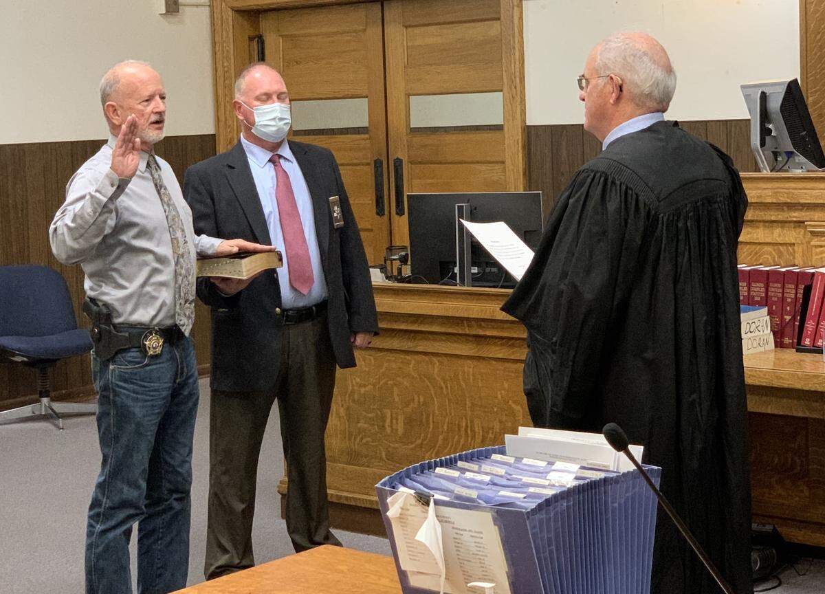 Judge Mark Stedelin swears in Marion County Coroner Troy Cannon for a third term on Nov. 30, 2020, as Bailiff Greg Smith holds the Bible.
