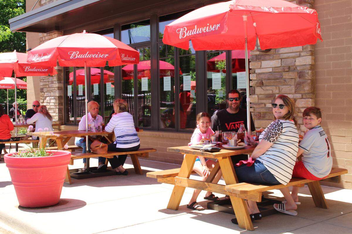 Ryan and Kelly Hoelting and their two children, Rainn, 11, far right at table in foreground, and Elliott, far left, enjoy lunch outside at Mike Shannon’s Grill in Edwardsville on Friday.