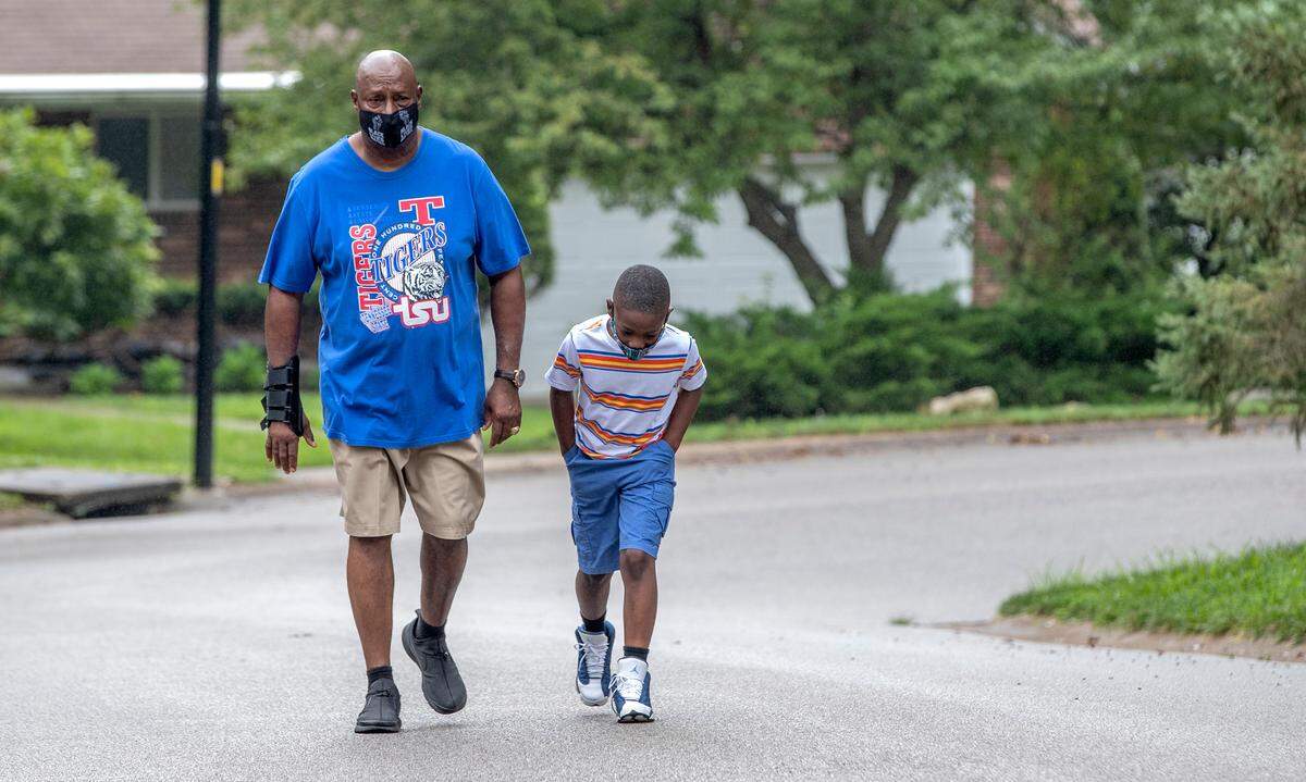 Kevin Anderson walks in his Fairview Heights neighborhood every day with his 8-year-old grandson, Ramon Gates Jr., to help build stamina three months after spending 35 days in the hospital with COVID-19. He still gets winded and exhausted.