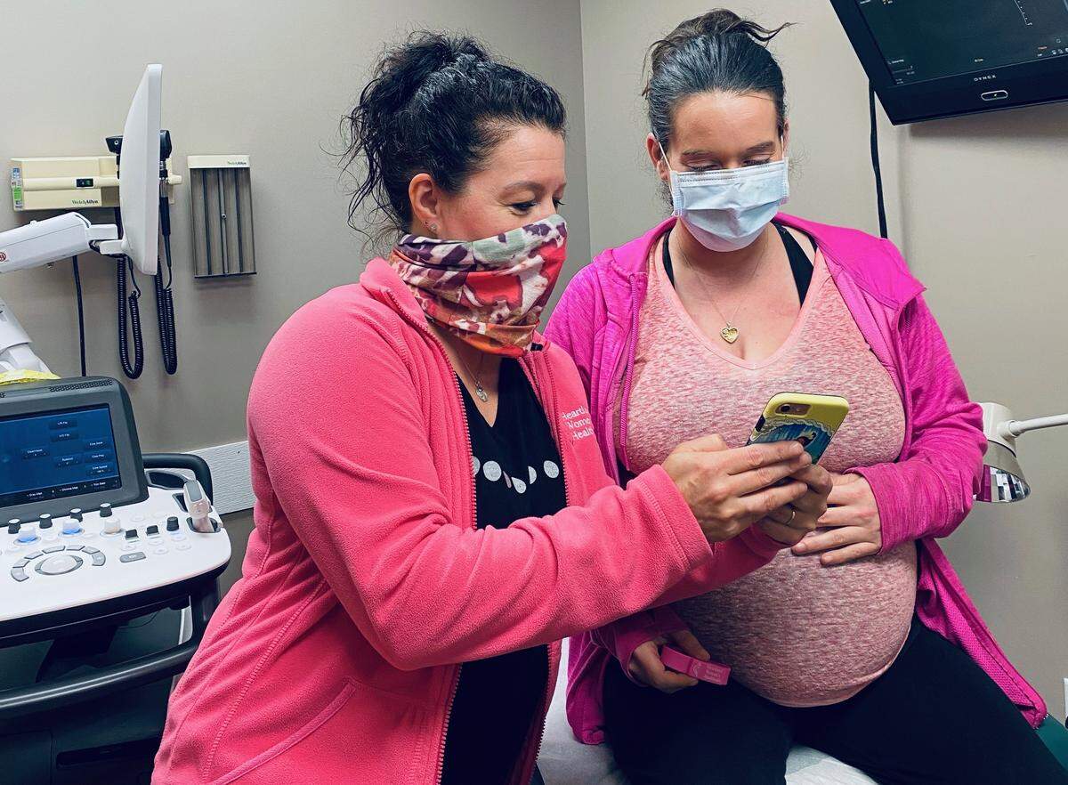Certified nurse midwife Tressie Landreth, left, explains to patient Judith Simmons how the telehealth system works in the Marion location of Heartland Women’s Healthcare.