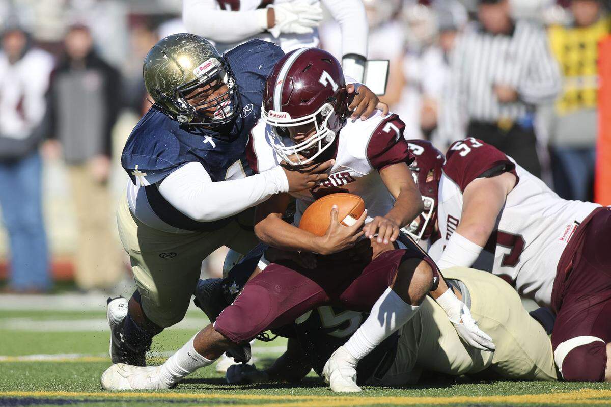 Althoff’s Christopher Jenkins and Chris Hobson get to Red Bud’s Dylan Oliver for a sack during an IHSA Class 2A second round playoff game against Red Bud. The Crusaders prevailed 26-14 and now advance to the quarterfinal round.
