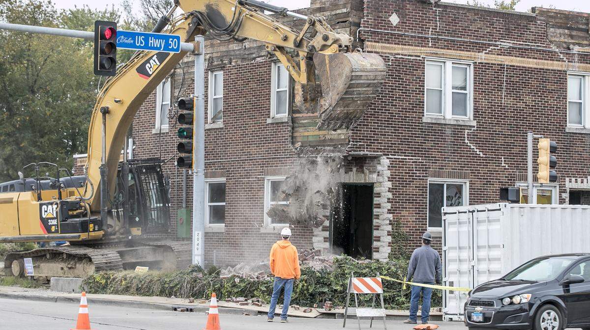An excavator with a giant claw-like bucket makes its way to the front of the old Dandy Inn building in Fairview Heights on Thursday. Plans call for construction of a new Moto convenience store and gas station on the site.