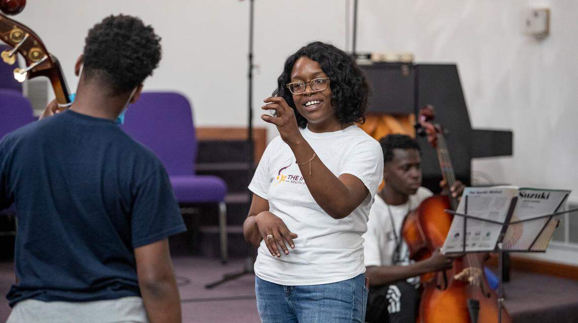 Rosalind Denise Rogers works with Carl Hill and William Austin during a music lesson.