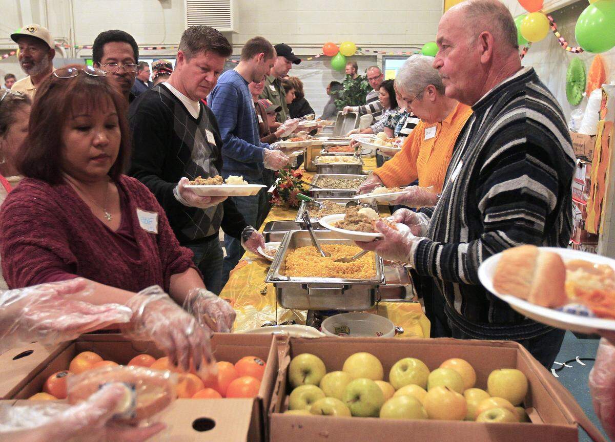 This 2015 file photo shows plates of food being passed down an assembly line of volunteers at a Society of St. Vincent de Paul Thanksgiving meal at St. Luke’s Catholic Church Parish Hall in Belleville.