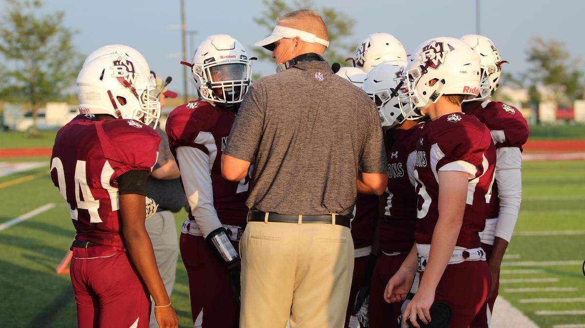 Belleville West coach Cameron Pettus huddles with his offense before kick off.