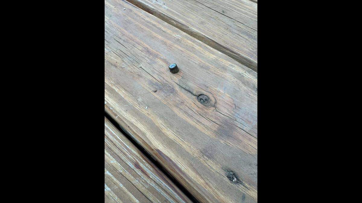 A 9mm bullet is embedded in the backyard deck of Swansea residents Tim and Micah Sexton. Police believe the bullet may have been fired into the air from up to three miles away.