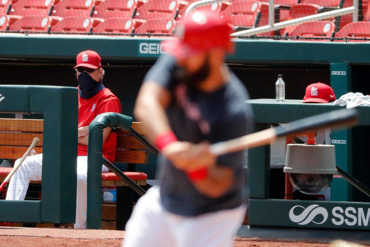 St. Louis Cardinals manager Mike Shildt, left, watches from the dugout as designated hitter Matt Carpenter bats during baseball practice at Busch Stadium. (AP Photo/Jeff Roberson)