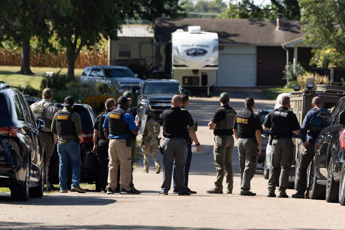 State, county and municipal police stare toward a house during a standoff in the 1800 block of Meadow Court in Columbia, Ill.