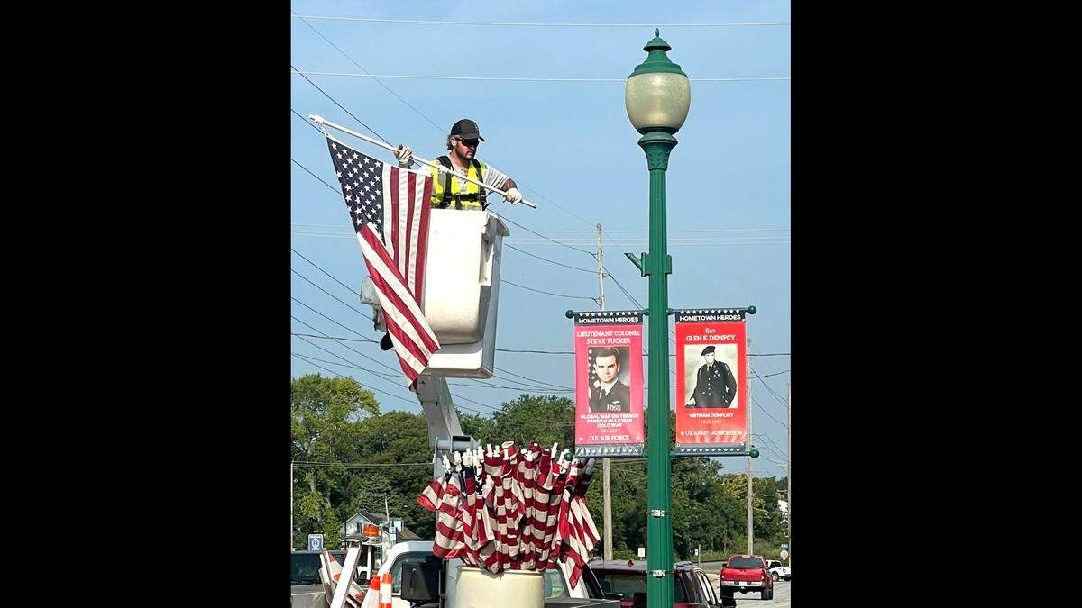 Chris Carrell of the O’Fallon Public Works Department braves early morning heat and humidity to put up (and later take down) over 70 American flags to adorn the streets of O’Fallon in preparation for the annual Independence Day celebration.
