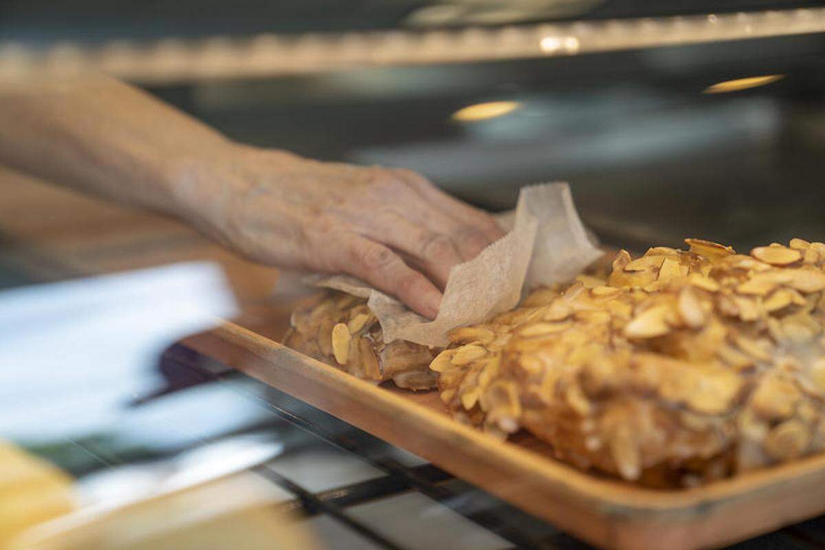 A worker at Kruta’s Bakery selects a bear claw for a customer’s order in this file photo.