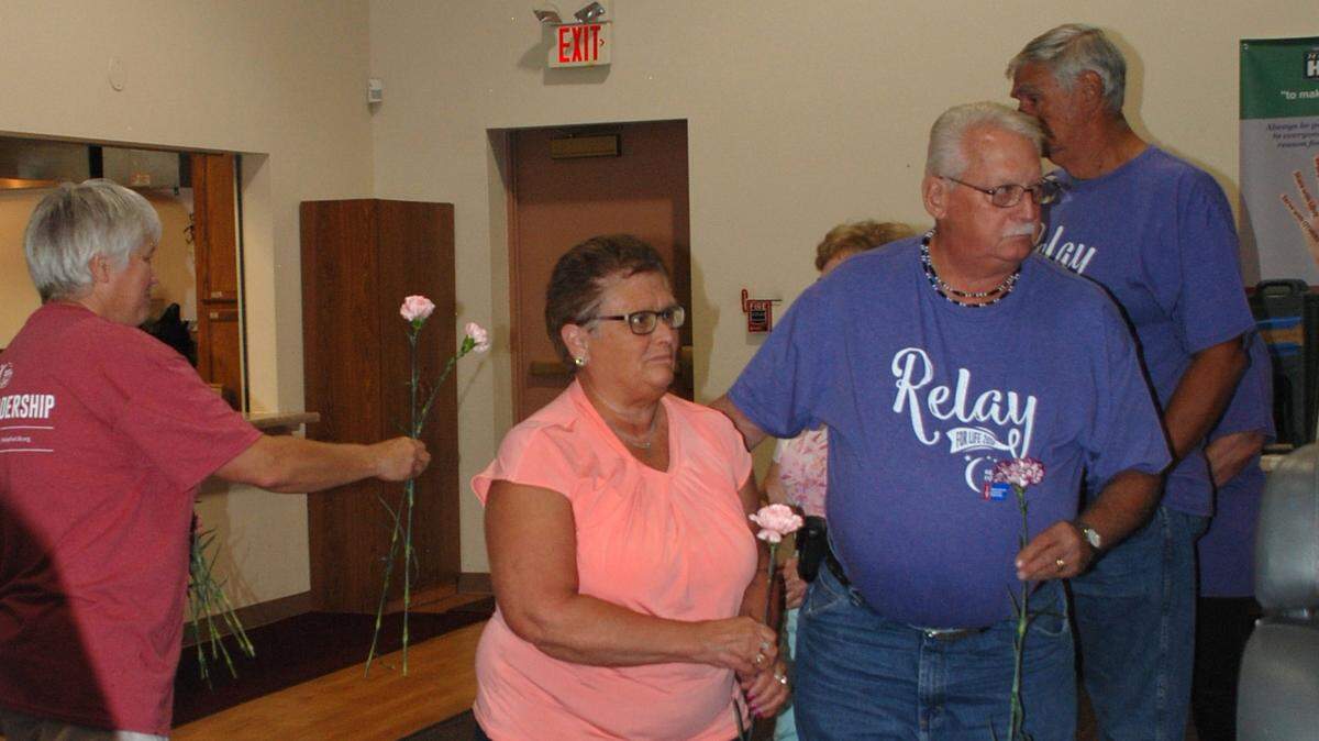 Kathy Walker hands out flowers to to cancer survivors during the survivor lap at the Highland Relay For Life in 2018. In front are Nancy and Russ Rieke. This year’s Highland Relay for Life Celebration Night is scheduled for Saturday, July 20, at Hope United Methodist Church, 12846 Daiber Road, Highland.