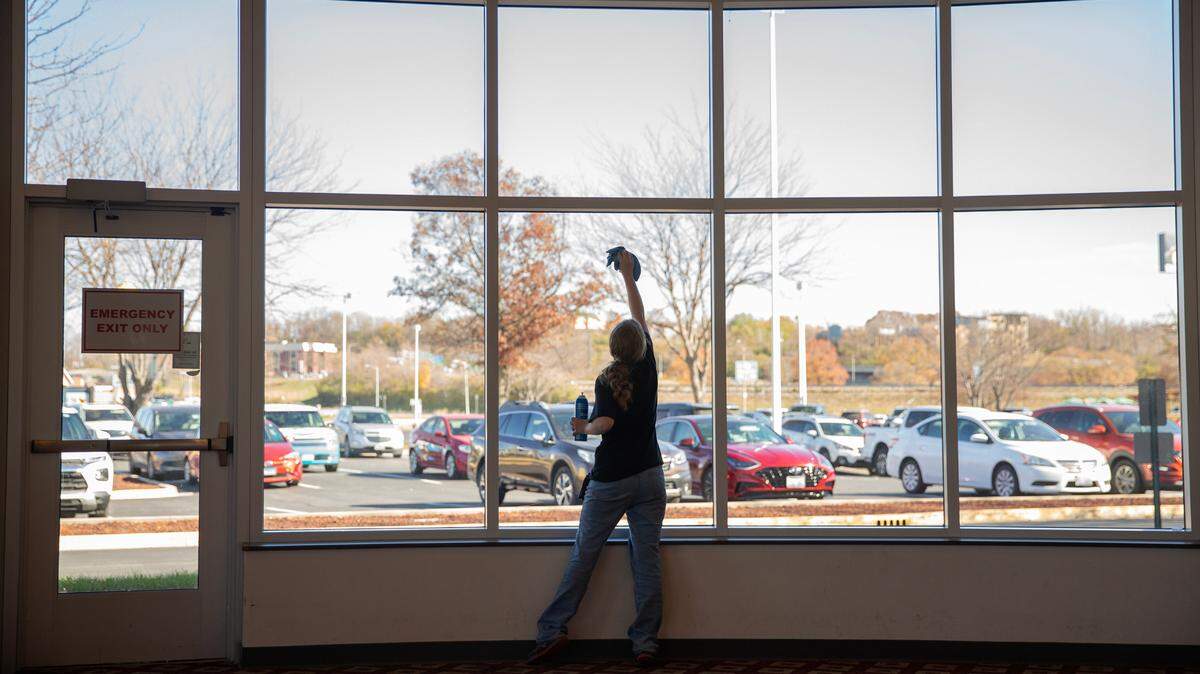 Mackensie Walker, 17, cleans windows in preparation for an upcoming event on Tuesday, Nov. 14, 2023, at the Gateway Convention Center in Collinsville, Ill. Walker is a senior at Collinsville High School and a part of an apprenticeship program for students with disabilities.