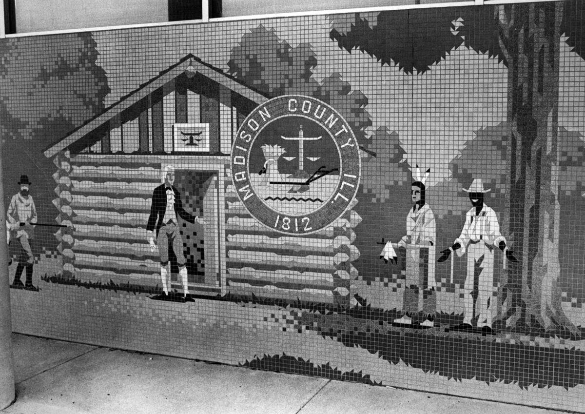 The mural on the old Edwardsville City Hall originally showed a freed slave with an exaggerated smile, straw hat and ropes dangling from his wrists. In 1988, he became a farmer with a hoe slung over his shoulder.