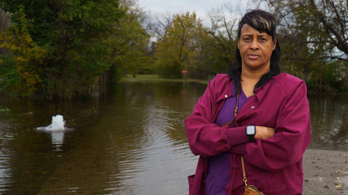 Terry Barnes, 58, stands in front of the flood of water on her street, Belmont Ave in East St. Louis, IL on Wednesday, Nov. 6, 2024.
