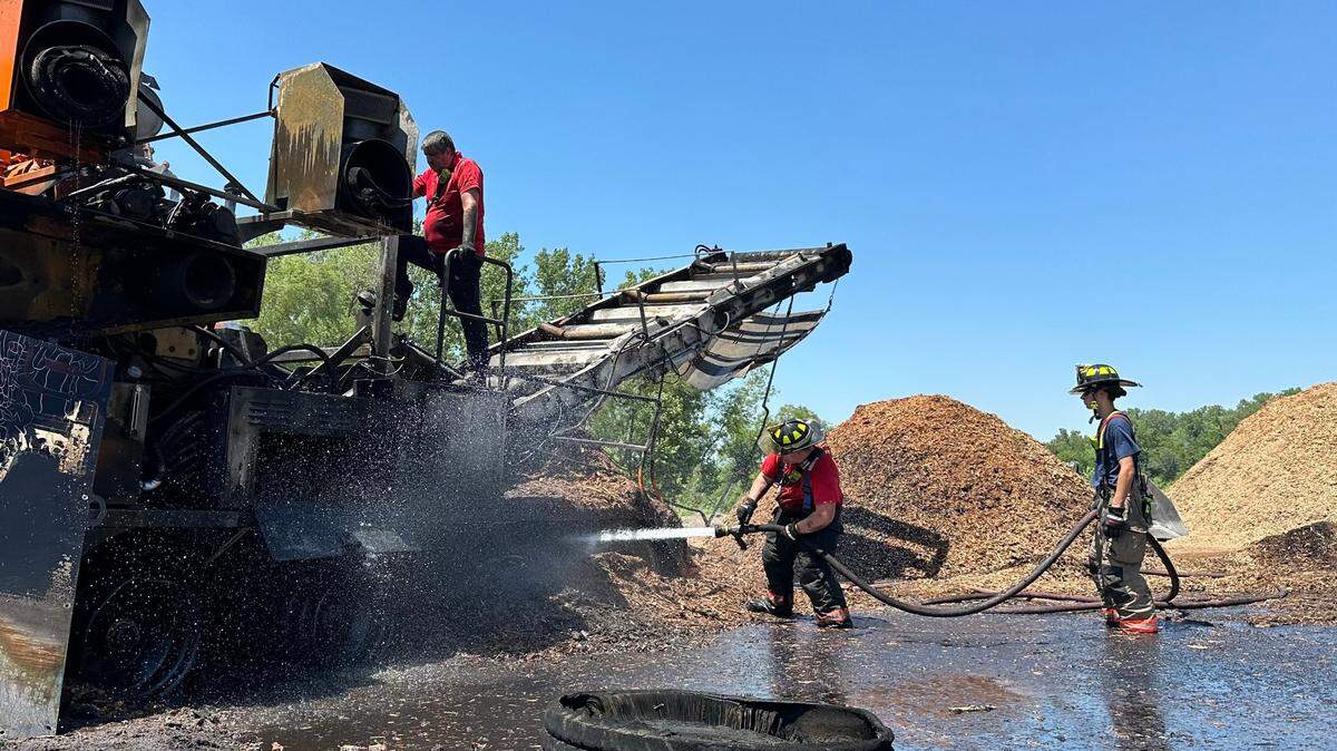 A trio of firefighters extinguish a fire started by a conveyor in Cahokia Heights on June 13, 2024. The fire was started due to a malfunction caused by debris, and spread to at least two mulch piles.