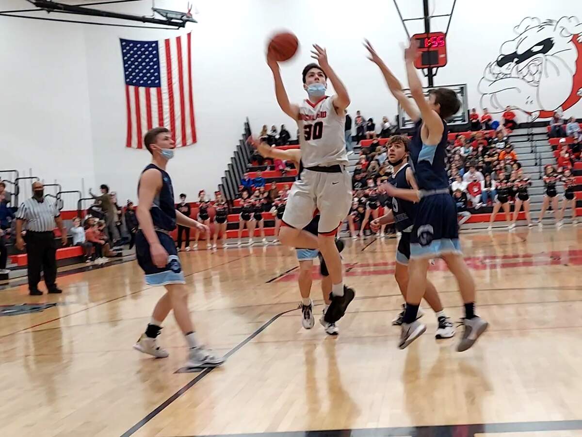 Highland freshman forward Grant Fleming goes up for a shot between two Jerseyville defenders Friday, Jan. 28, in a Mississippi Valley Conference basketball game at Highland High School. Fleming scored 6 points in the Bulldogs 50-36 loss to Jerseyville.