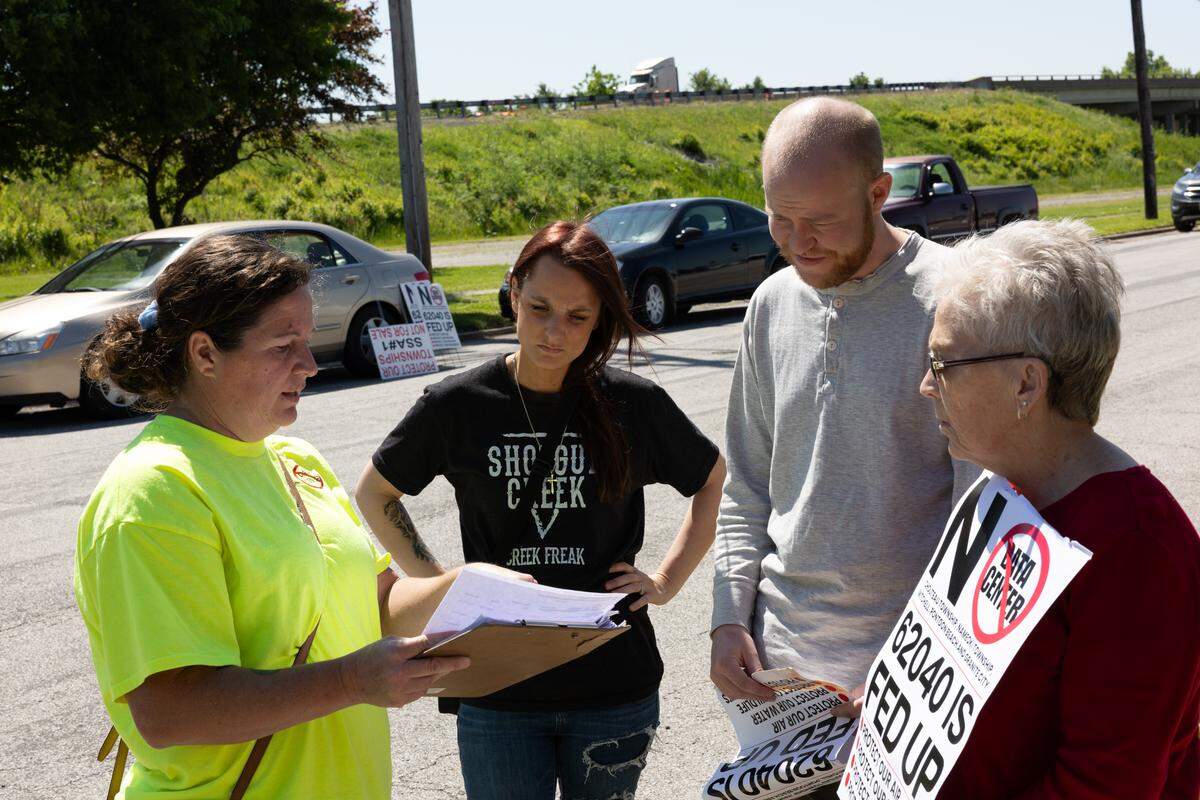 Heather Groetecke helps fellow protesters opposed to data centers sign up to speak prior to a board meeting for America’s Central Port District on May 11.