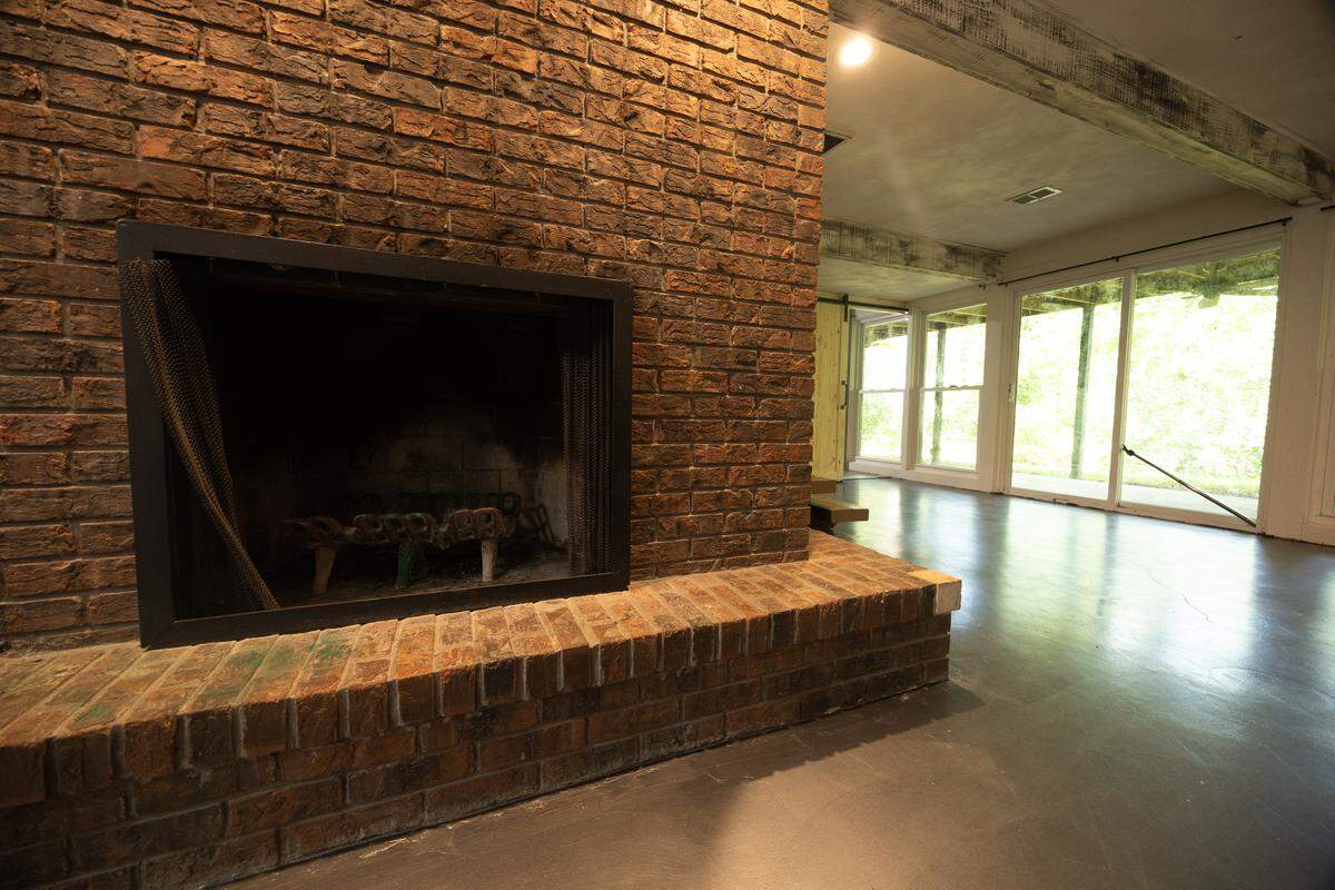 A wood-burning fireplace breaks up the open space of the large, finished basement.