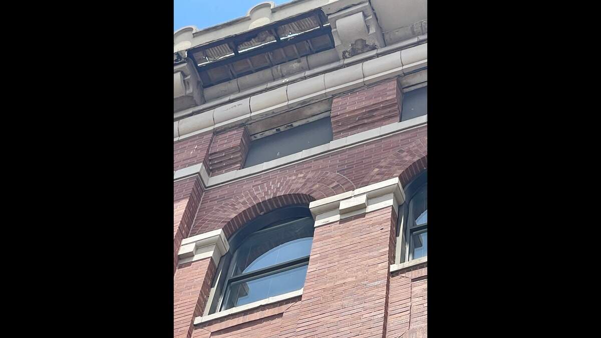 A section of the Market Square Building where a piece of the decorative roof overhang is missing. The city of Belleville has blocked off the sidewalk in front of the building.