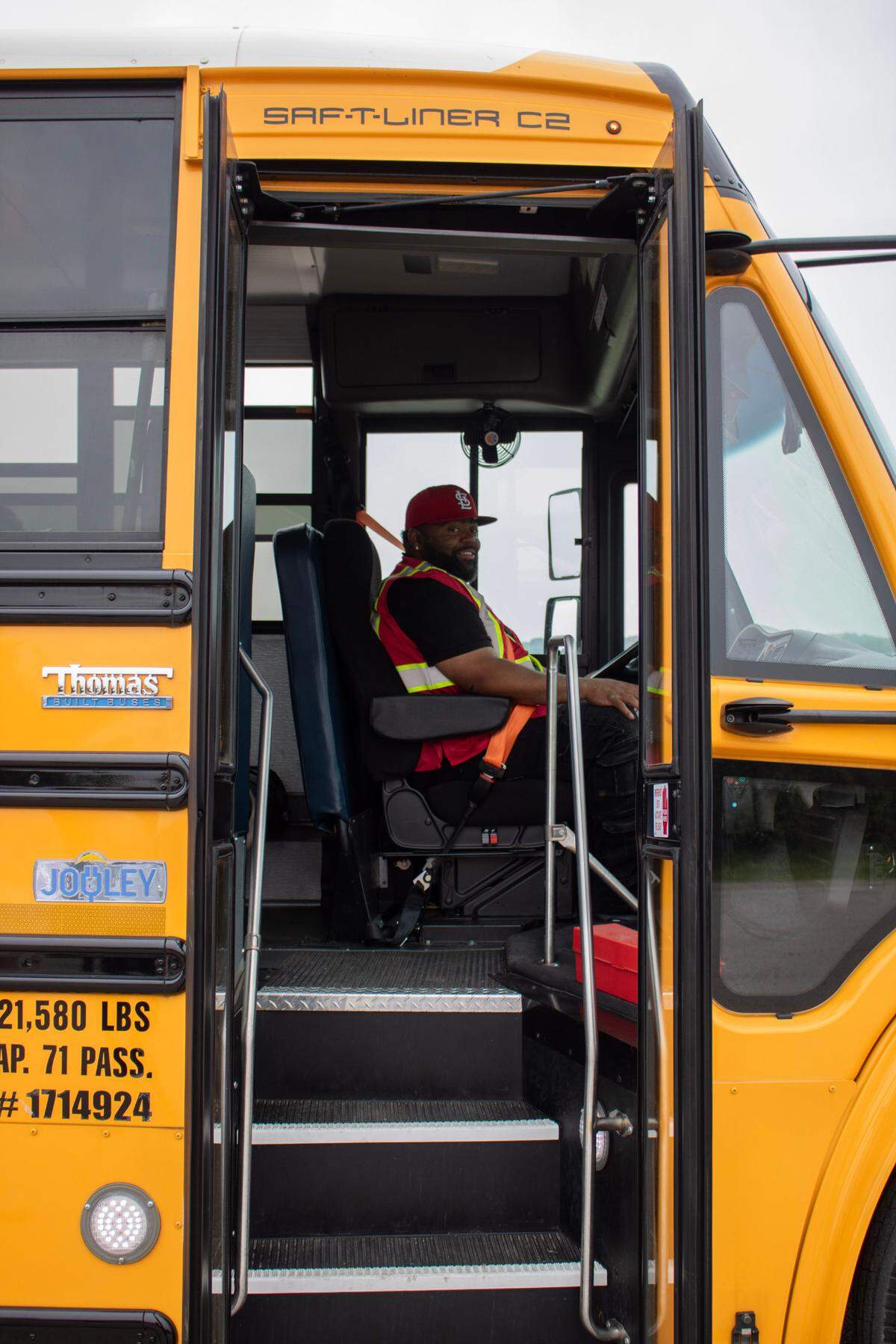 Arnandez Washington, a bus driver trainer for Illinois Central School Bus, smiles on in East St. Louis District 189’s new electric school bus during an event on Thursday, June 12, 2025. He later gave a free bus ride for attendees of the event, doing a circle down Bunkum Road, Black Lane, Forest Boulevard and N 81st St. before ending up back at the Illinois Central School Bus Garage.