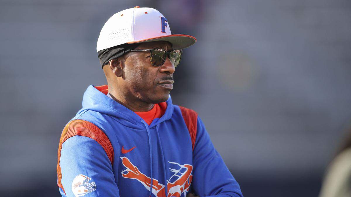 East St. Louis High School coach Darren Sunkett watches his football team warm up Saturday prior to the IHSA Class 6A state championship game against Crystal Lake Prairie Ridge at Memorial Stadium on the University of Illinois campus in Champaign.