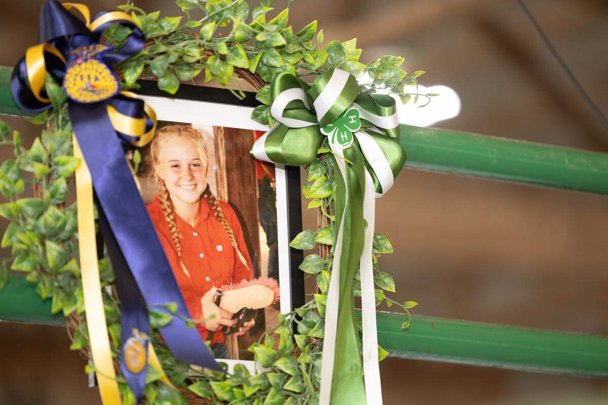 A portrait of Emma Schultheis hangs above the livestock auction block at the Monroe County Fair in Waterloo.