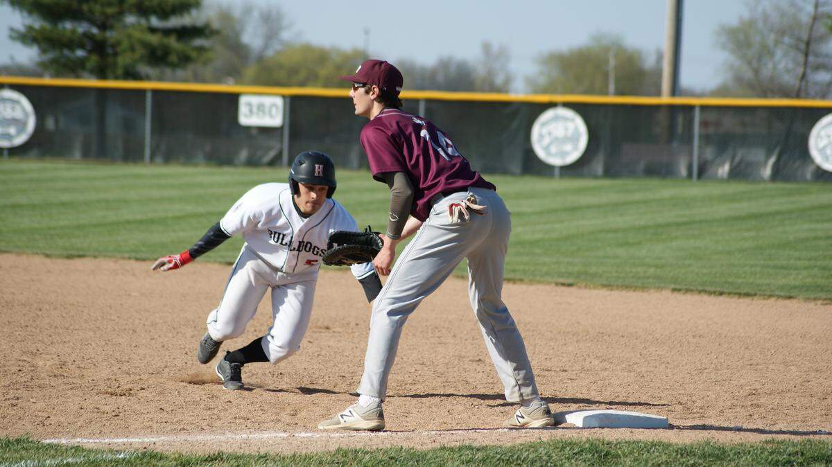 Highland senior Evan Herman starts to retreat back to first base while Belleville West first baseman Hunter Grupe waits for the throw from his pitcher during the Bulldogs' 6-3 victory over the Maroons Friday at Glik Park in Highland.