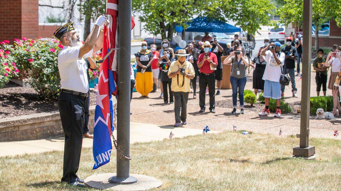 American Legion Post 2505 member Harvey Jackson attaches a Juneteenth flag outside of East St. Louis city hall.