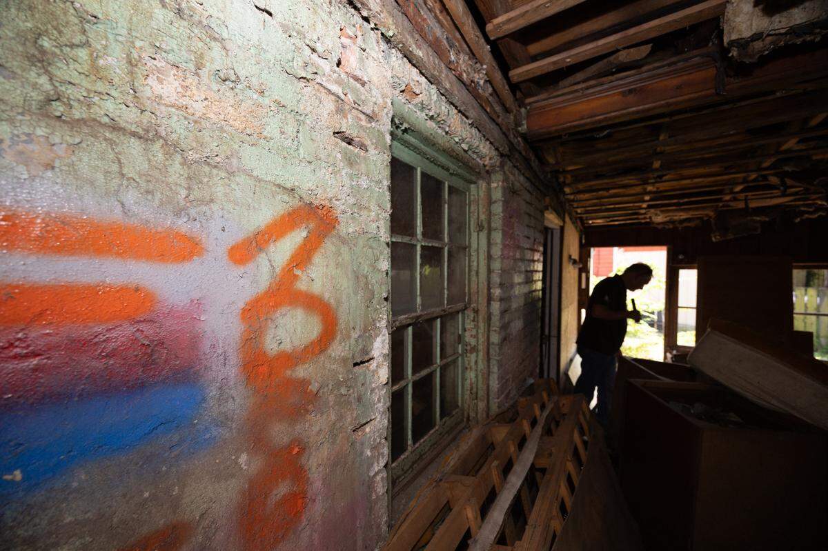 Belleville Building Commissioner Steve Thouvenot walks the exterior of the condemned property at 217 N. Jackson in Belleville, where graffiti has been sprayed on the wall.