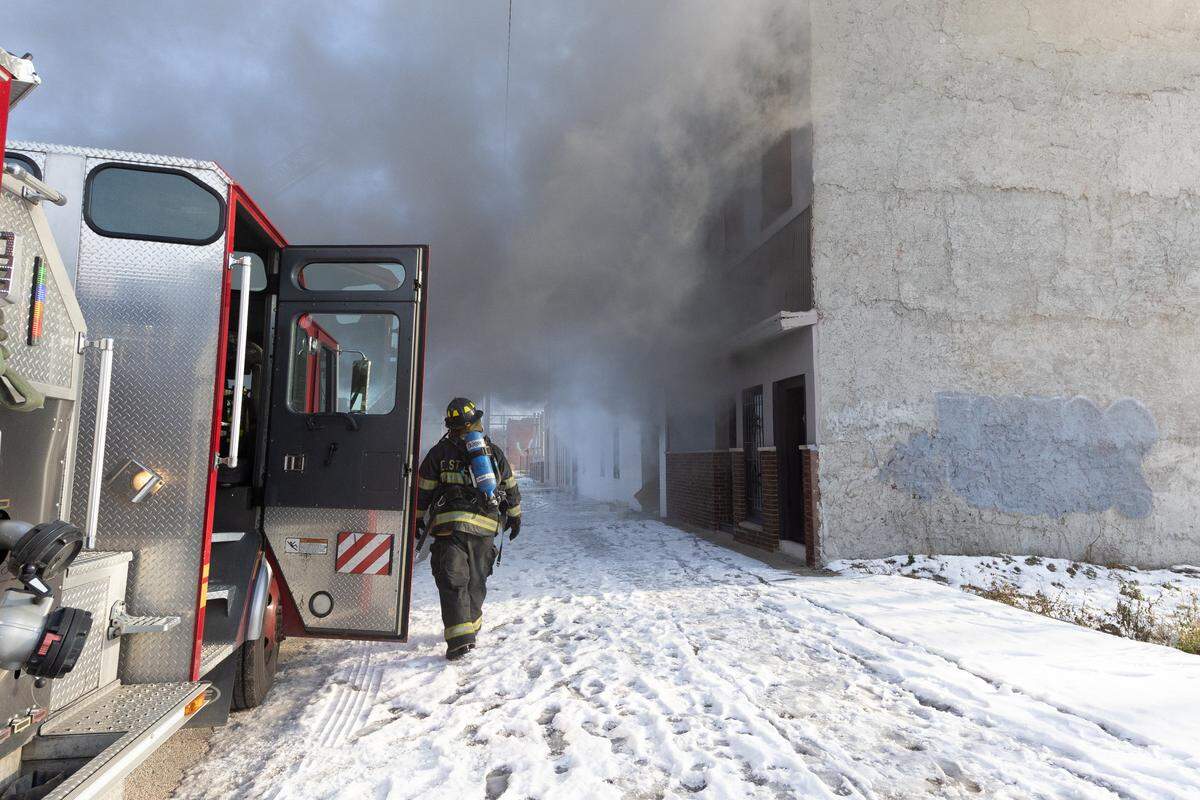 Firefighters at the scene of the Thursday fire check to make sure the fire isn’t spreading to nearby structures.