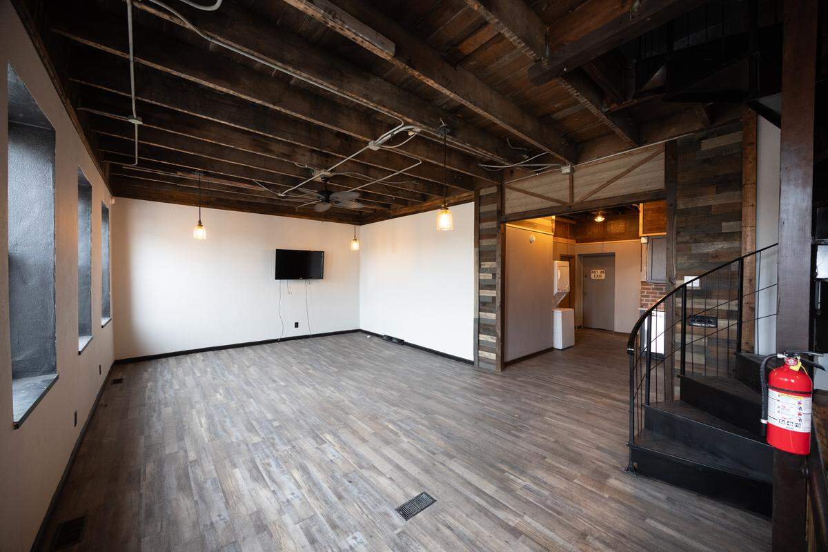 An open living room, spiraling staircase, laundry room and kitchen greet you as you enter into the apartment.