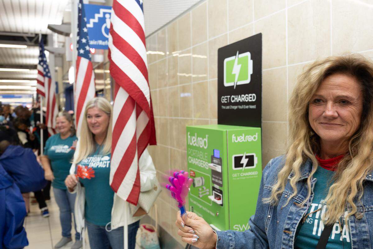 A volunteer shakes a noisemaker as veterans on the Greater St. Louis Honor Flight return home.