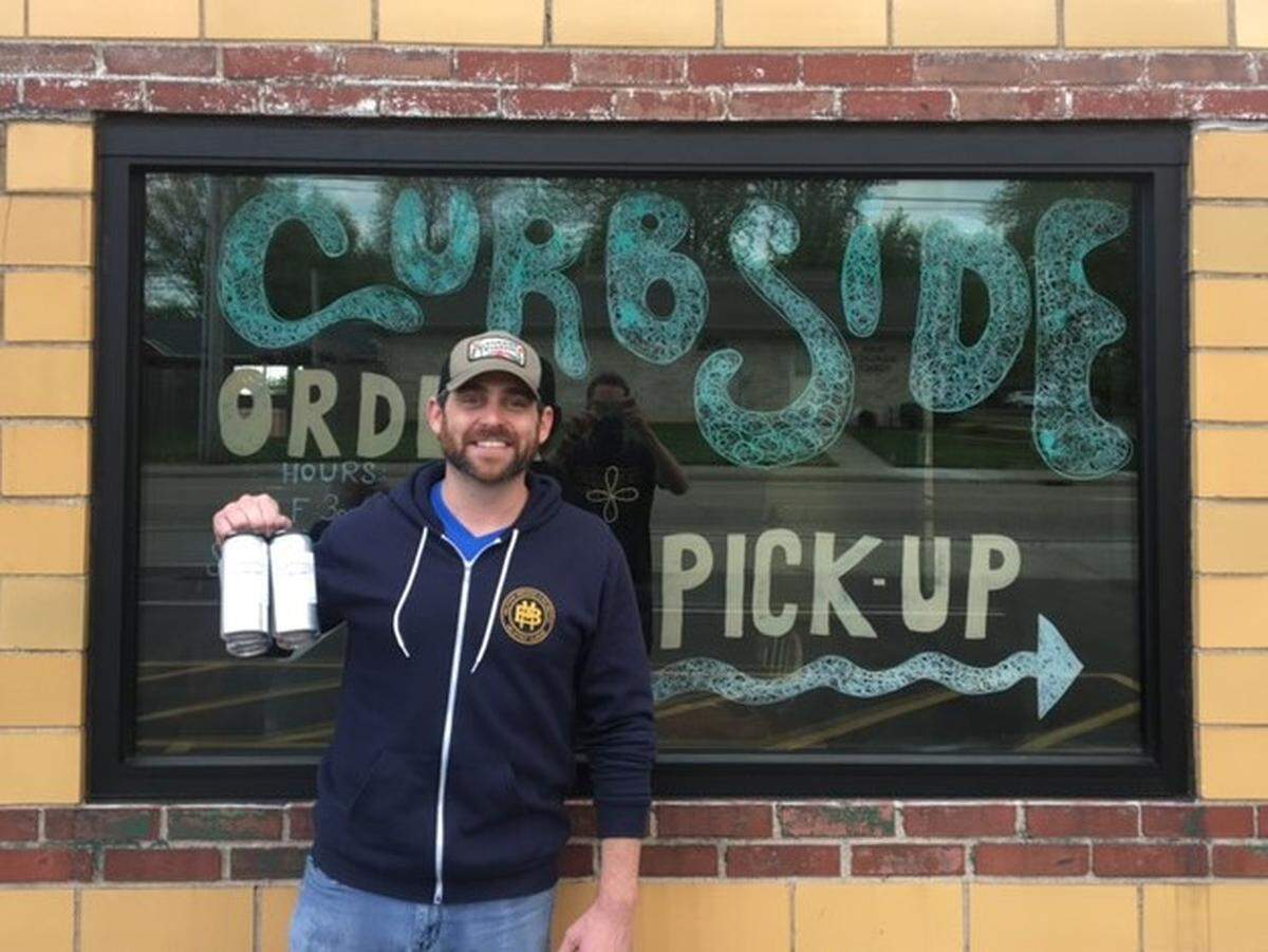 Bryan Schubert, owner of Millpond Brewing & Incubator in Millstadt, shows off a four-pack of canned beer that the brewery is selling during the COVID-19 pandemic.
