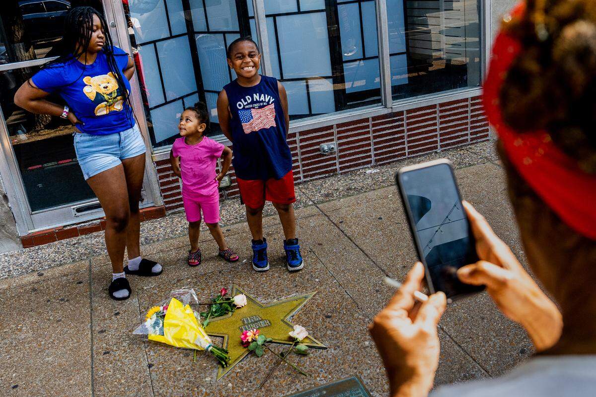 Barbara Martin, 72, of Kingsway West, snaps a photo of her grandchildren Miah McCellary, 16, Phynx Laurel, 2, and Rataka Marshall, 7, in front of Tina Turner’s star on the St. Louis Walk of Fame after her passing on Wednesday, May 24, 2023, on the Delmar Loop in University City. “Tina Turner’s death was a real shocker,” Martin said. “We’re really just losing all of our greats. Wow, just wow.”