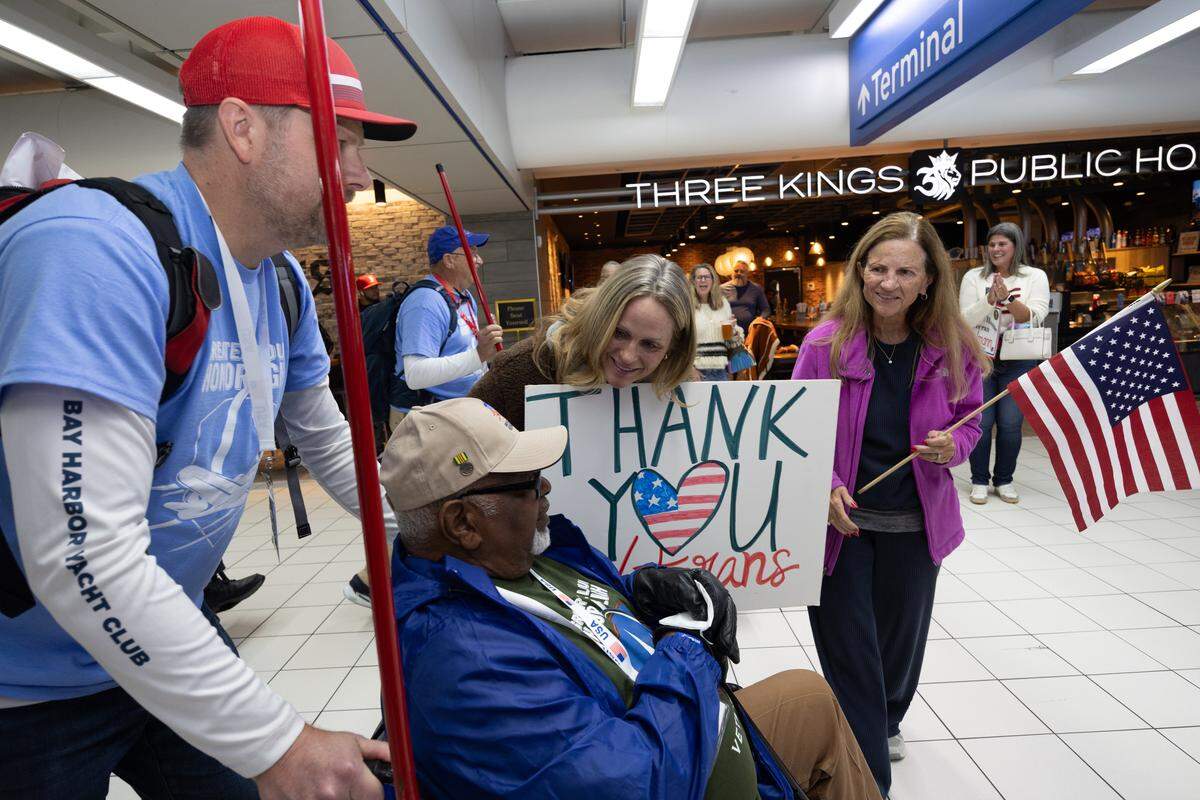 A Vietnam War veteran is greeted by a supporter as he traverses Lambert airport as part of the welcoming parade. 