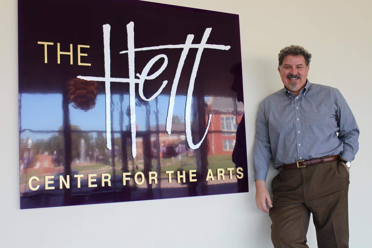 Peter Palermo poses in the lobby of The Russel E. and Fern M. Hettenhausen Center for the Arts. In this photo, The Hett sign reflects windows looking out on the McKendree University campus in Lebanon.