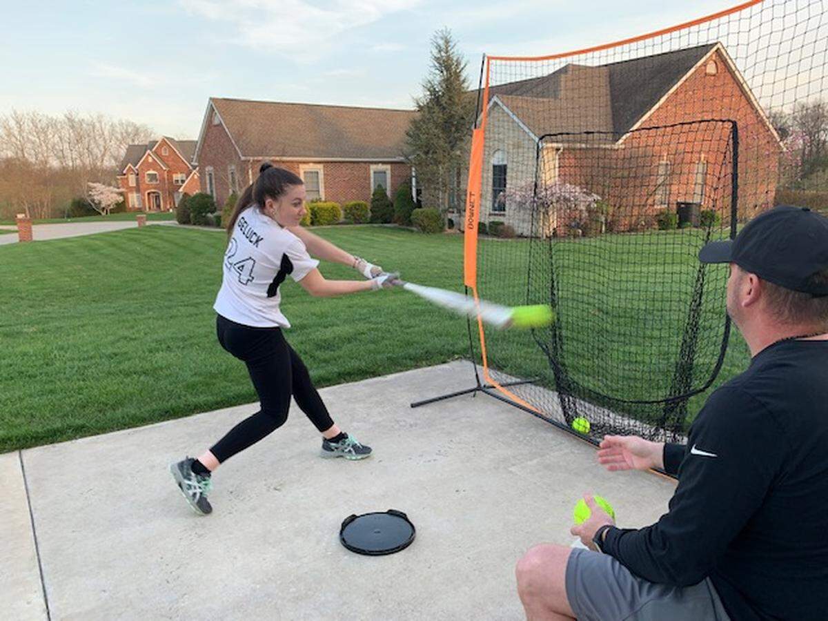 Taylor Geluck, a junior at Belleville West High School, goes through softball drills with her father, Brian, even though her team’s 2020 season is on hold due to the coronavirus pandemic.