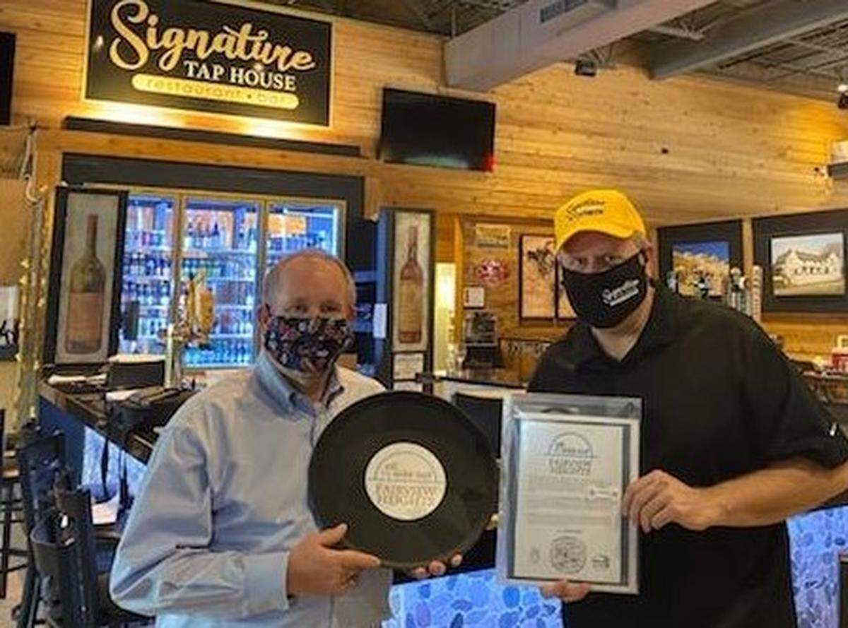 Fairview Heights Mayor Mark Kupsky, left, stops by Signature Tap House to present owner Brandon McGraw with a packet explaining his options on expanding outdoor dining this weekend.