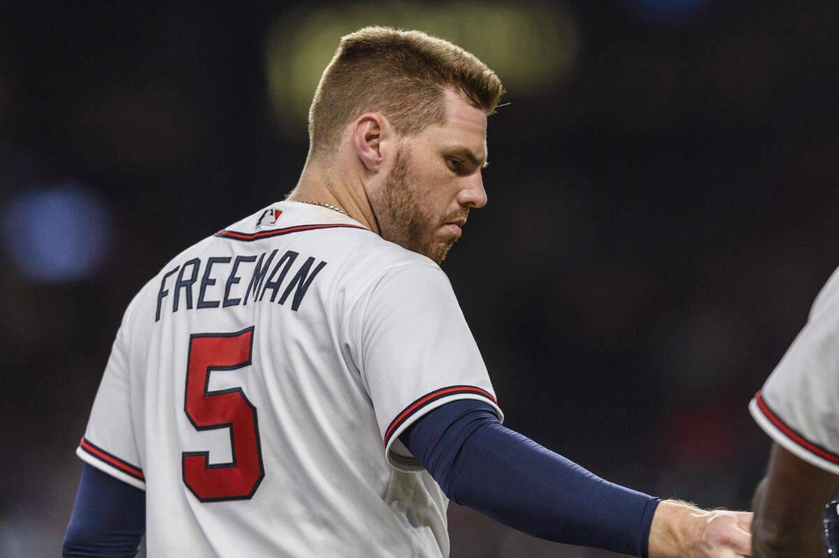 Atlanta Braves’ Freddie Freeman hands off his batting helmet after the eighth inning of a baseball game in Atlanta. The Braves’ best hitter is battling bone spurs. (AP Photo/Danny Karnik)