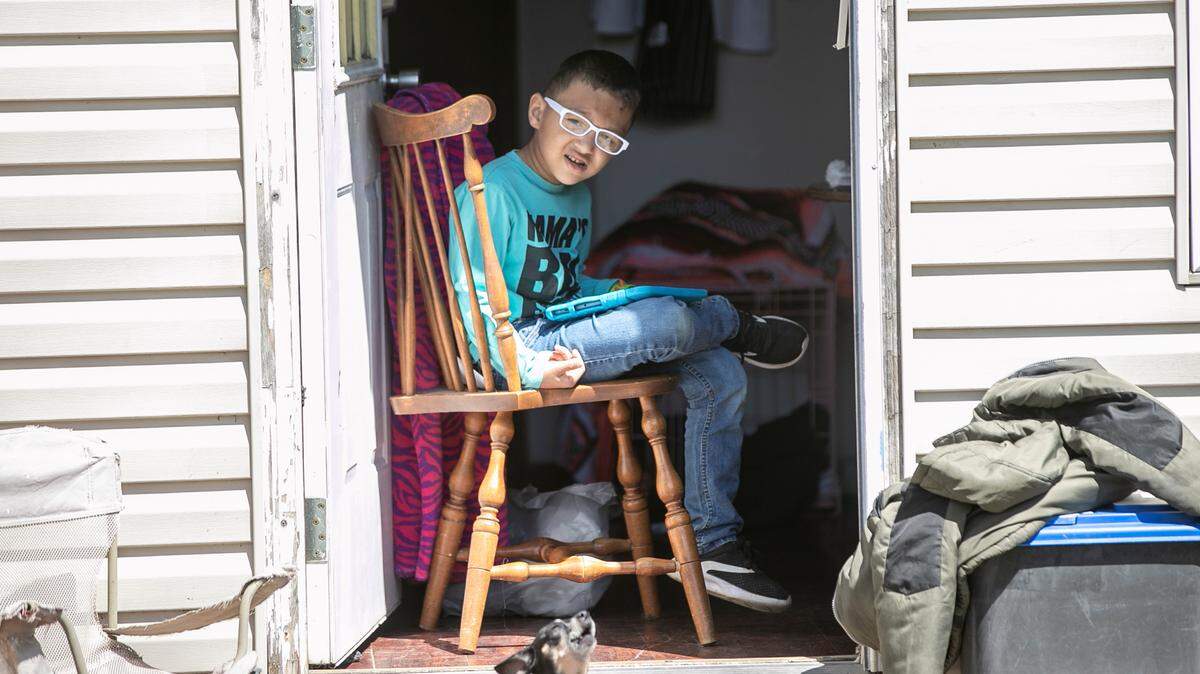 Five-year-old Braxton Lear pauses from playing on a tablet at a relatives house. His mother Shannon Lear has been very happy with the advancements he has made and hopes that funding will remain available for his autism therapy.