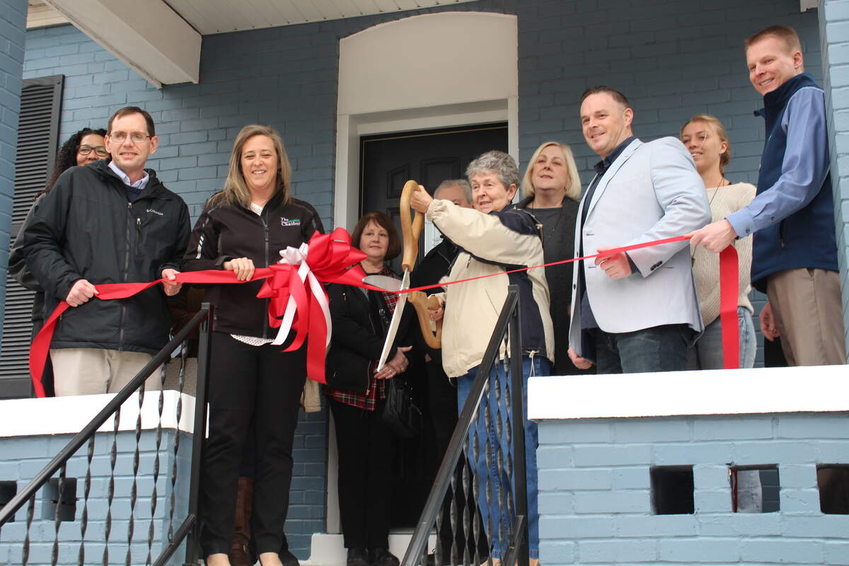 Mary Ann Brauer, board secretary for Belleville Community Development Corp., cuts the ribbon at a recently renovated home at 313 S. Ninth St. in Belleville on Tuesday.