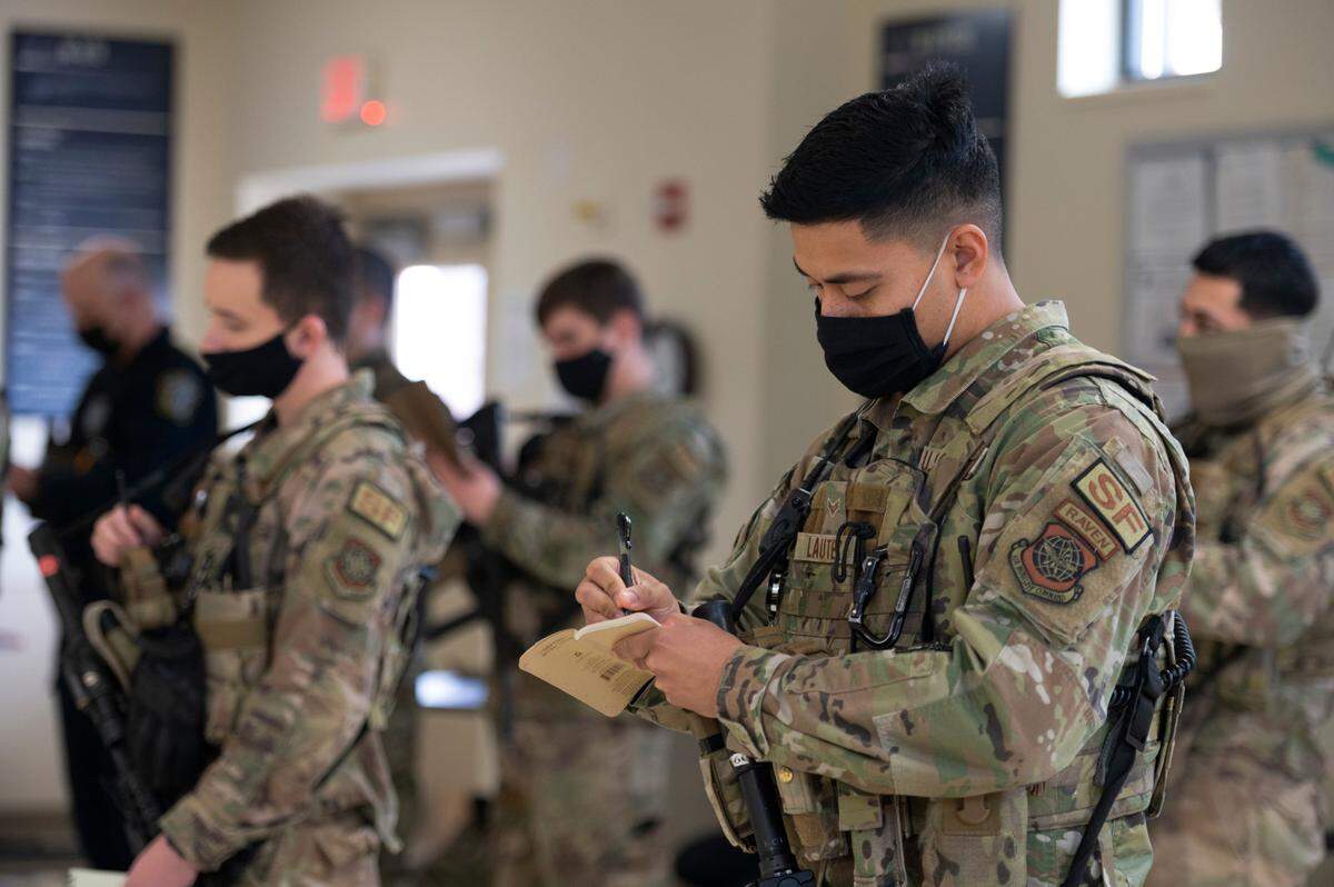 U.S. Air Force Airman 1st Class Keith Lautez, 375th Security Forces Squadron entry controller, uses a notepad to write down important information during guardmount on Scott Air Force Base. Lautez is certified as a Pheonix Raven, who are specially trained security forces personnel that provide security for Air Mobility Command aircraft transiting high terrorist and criminal threat areas.