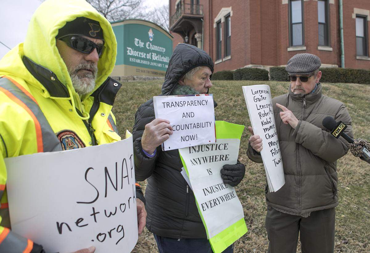 David Clohessy, right, speaks to reporters while protesting with John Duffin and Anne Harter outside the Catholic Diocese of Belleville chancery in 2019. All are activists with the Survivors Network of those Abused by Priests.