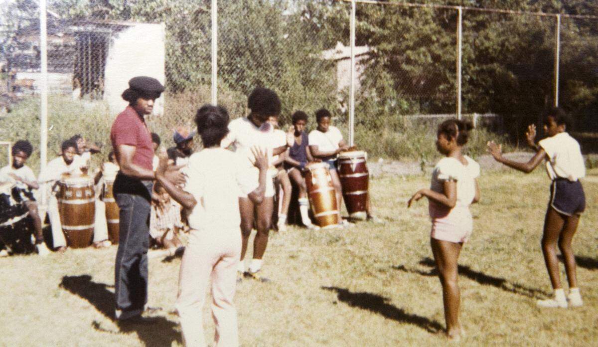Sylvester “Sunshine” Lee, in red shirt, started teaching boys in East St. Louis to play African drums in the mid-1970s. When girls asked to join, he found them a teacher for African dance.