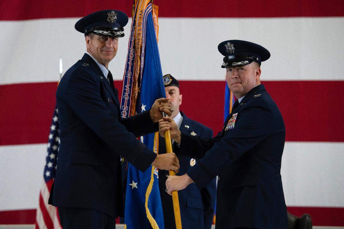 U.S. Air Force Col. John Poole, right, 375th Air Mobility Wing commander, assumes command of the 375th AMW after receiving the Wing’s guidon from Maj. Gen. Corey Martin, 18th Air Force commander, on Scott Air Force Base. The change of command ceremony represents a time-honored military tradition providing an opportunity for Airmen to witness the transfer of power to their newly appointed commanding officer.