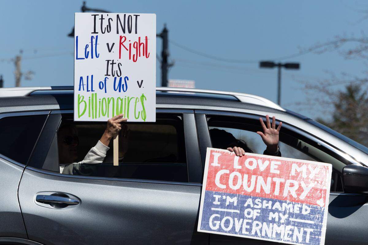 Some vehicles driving around Belleville Public Square on Saturday displayed signs to show support for the hundreds of people who had gathered as part of a No Kings national day of protest.