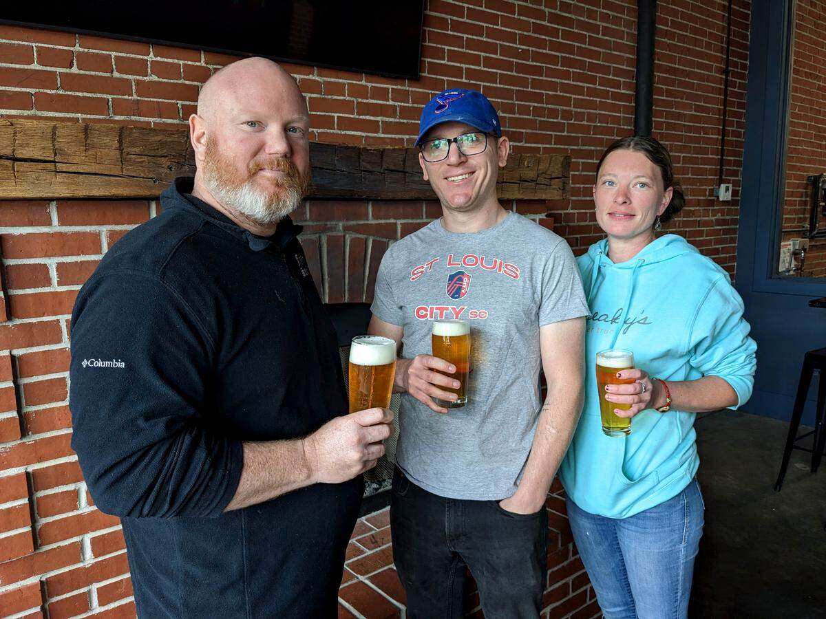 Sneaky’s Bar and Burger Joint co-owners Casey Hinman and Tyler Ottwein, and staff member Katie Webb